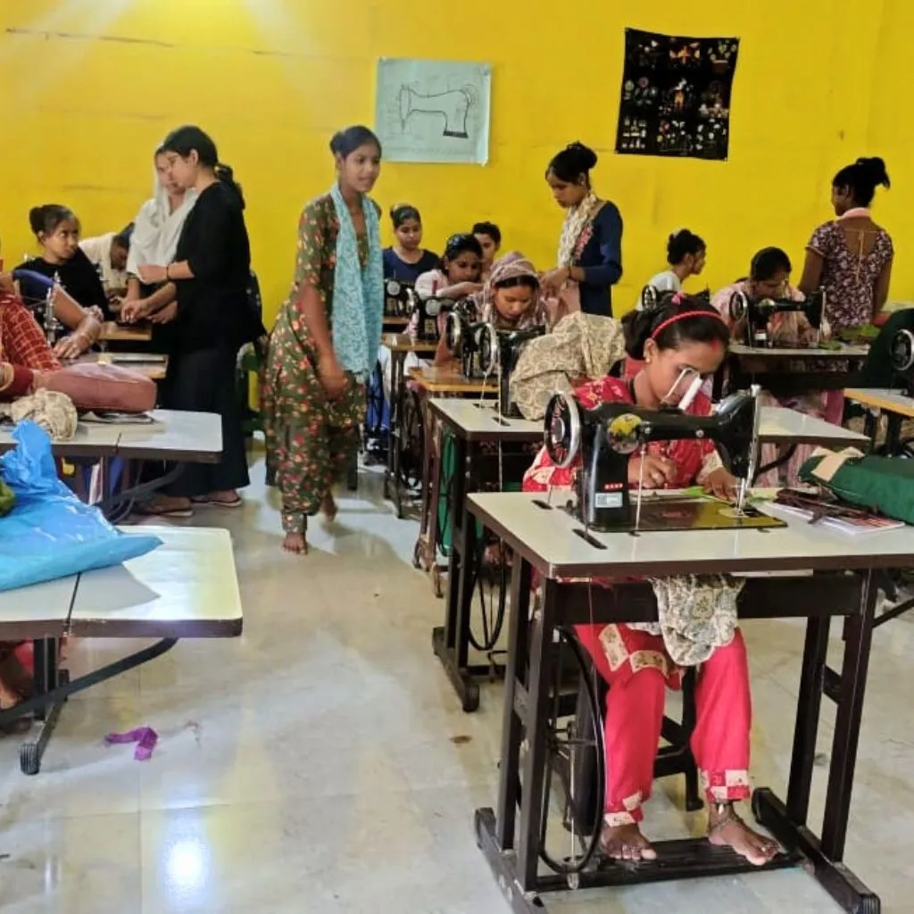 Women learning professional sewing skills at PlanCare's training center in Delhi